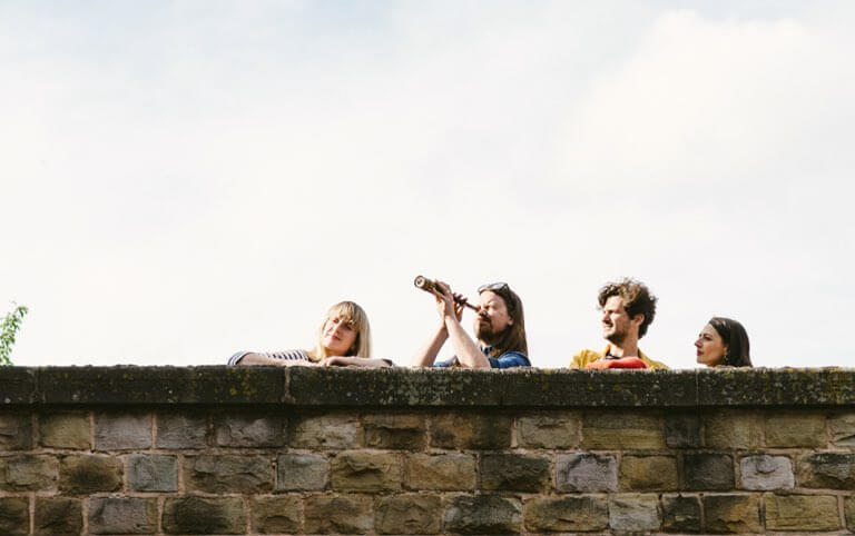 A group of friends looking for a clue from a bridge